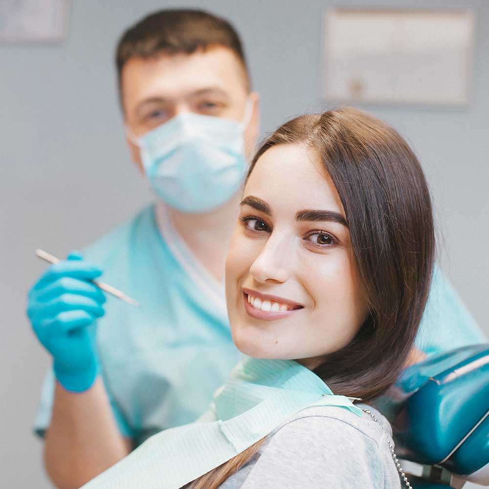 Patient smiling with dentist in background